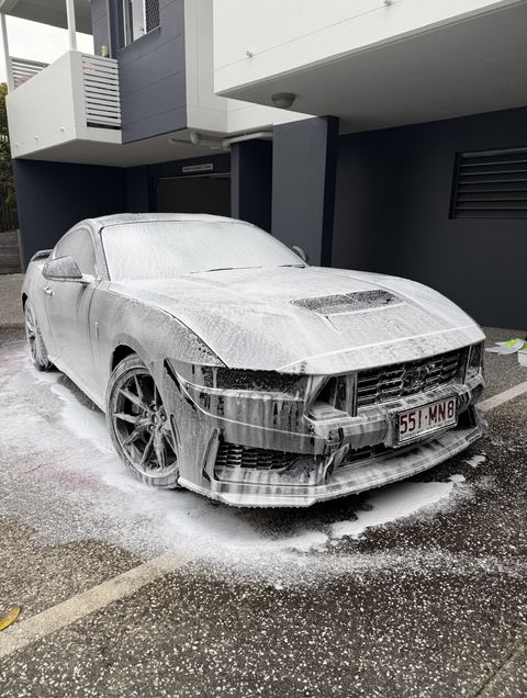 Ford Mustang Dark Horse front three-quarter covered in snow foam